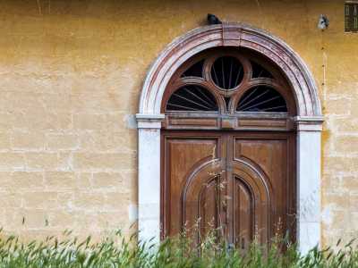 Il piano inferiore, contraddistinto da mattoni regolari color ocra, custodisce il portale in legno, mentre il superiore � scandito da tre porte finestre ad arco